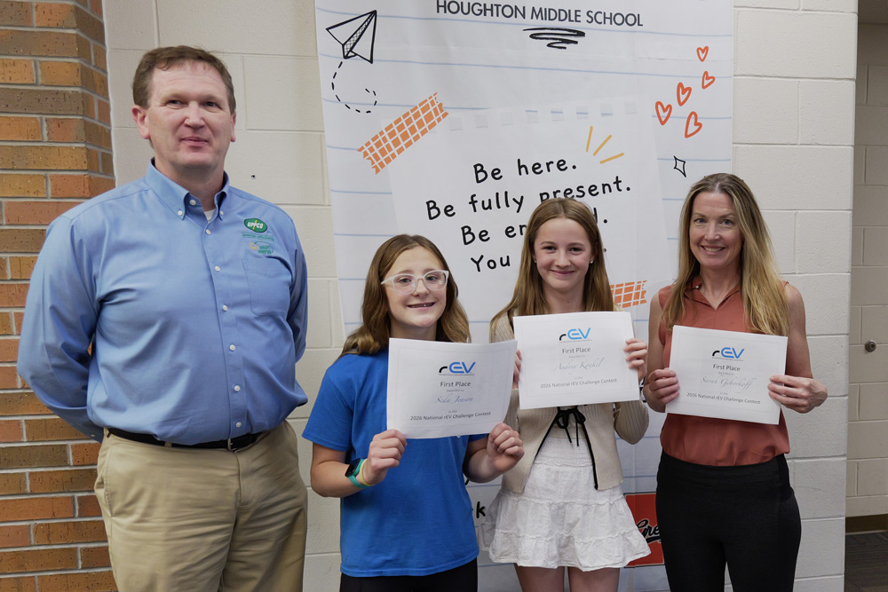 An UPPCO representative awards two Houghton Middle School students with their rEV Challenge certificates